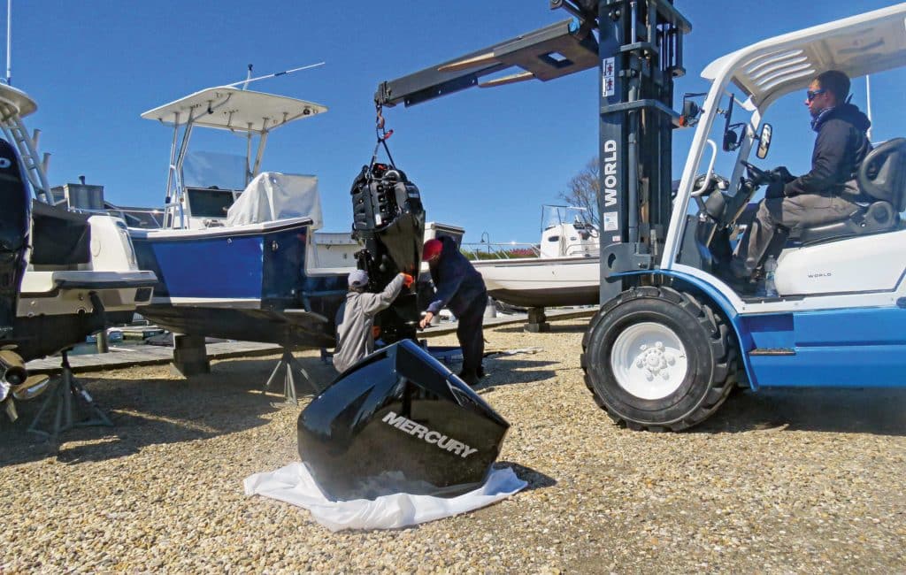 Boatyard technicians with Mercury outboard on a forklift