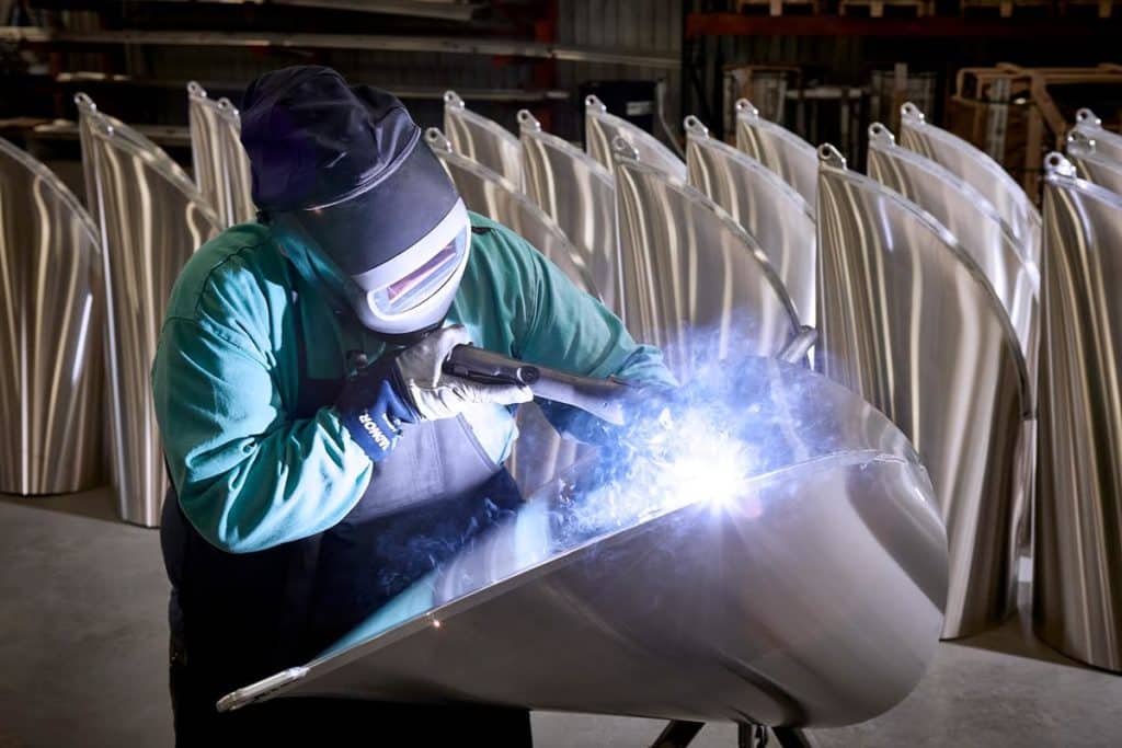 A welder working on a Bennington pontoon boat