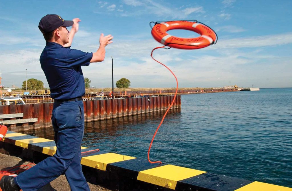 Coast Guard member tossing a PFD