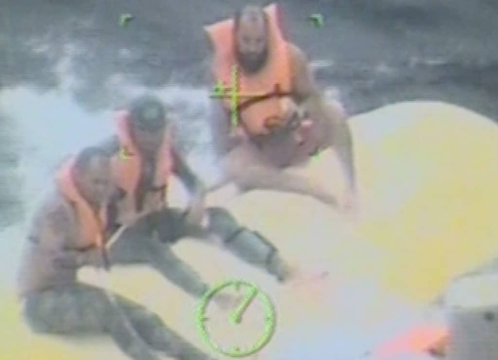 Spearfishermen on overturned boat