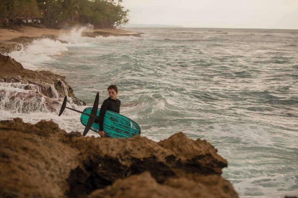 Carrying an eFoil along the rocky shoreline