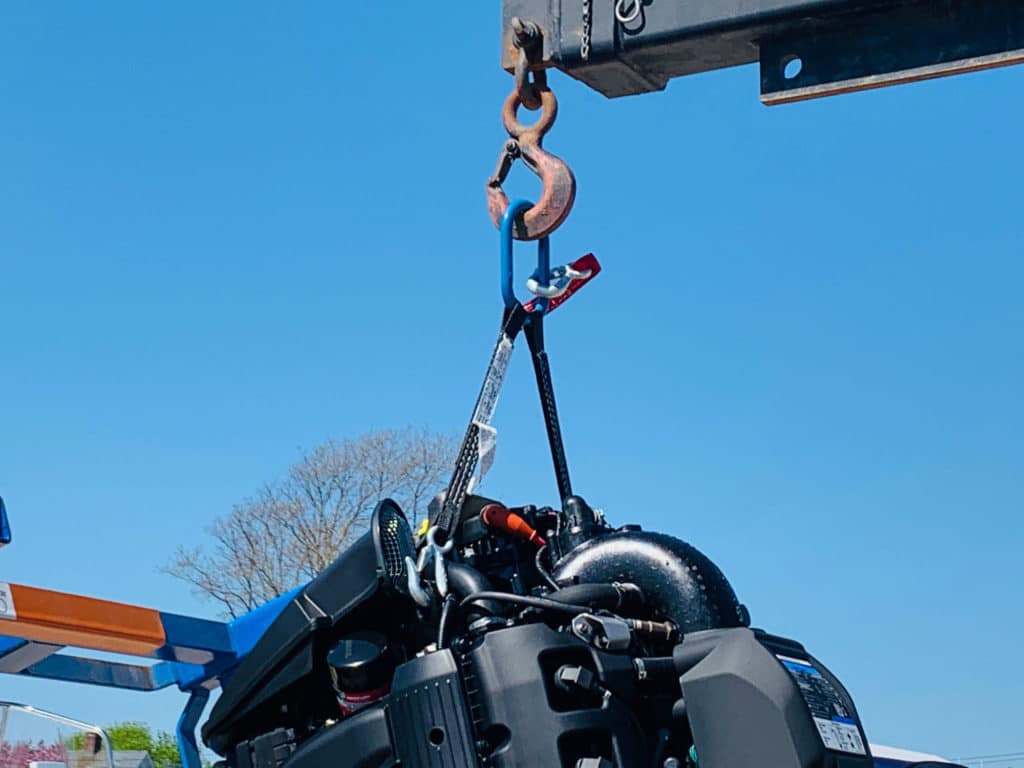 Outboard with harness attached to lifting eyes