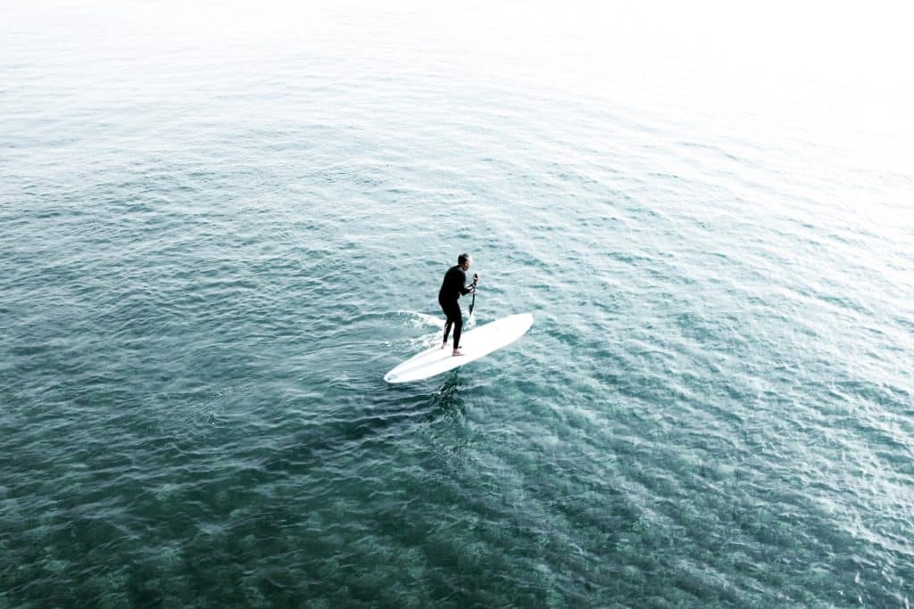 Man paddleboarding across a lake