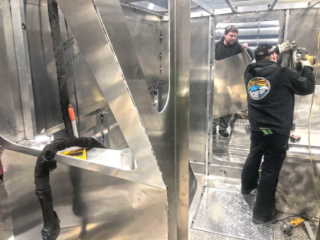 Workers fabricating aluminum boat