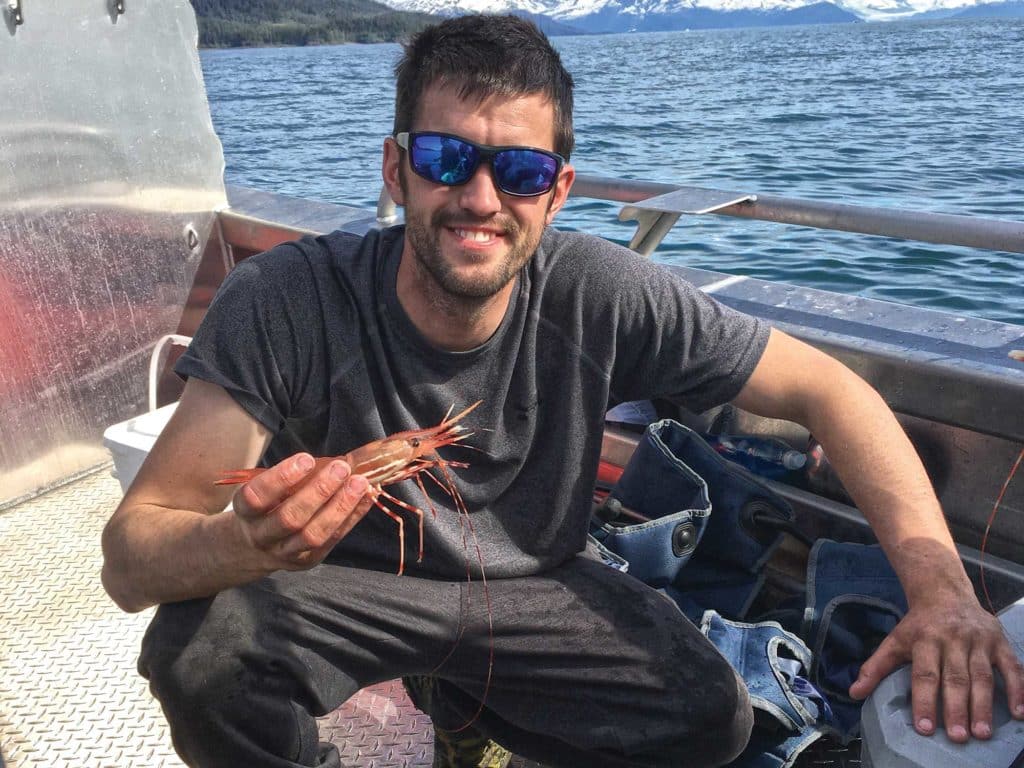 Holding up large shrimp in Alaska