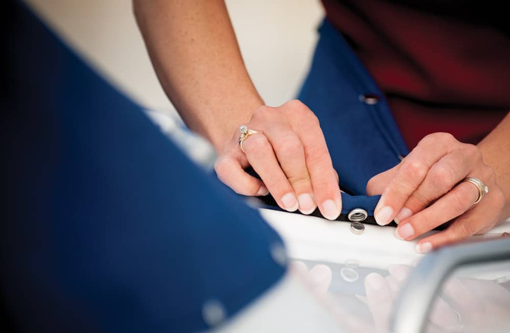 Snapping down a canvas boat cover